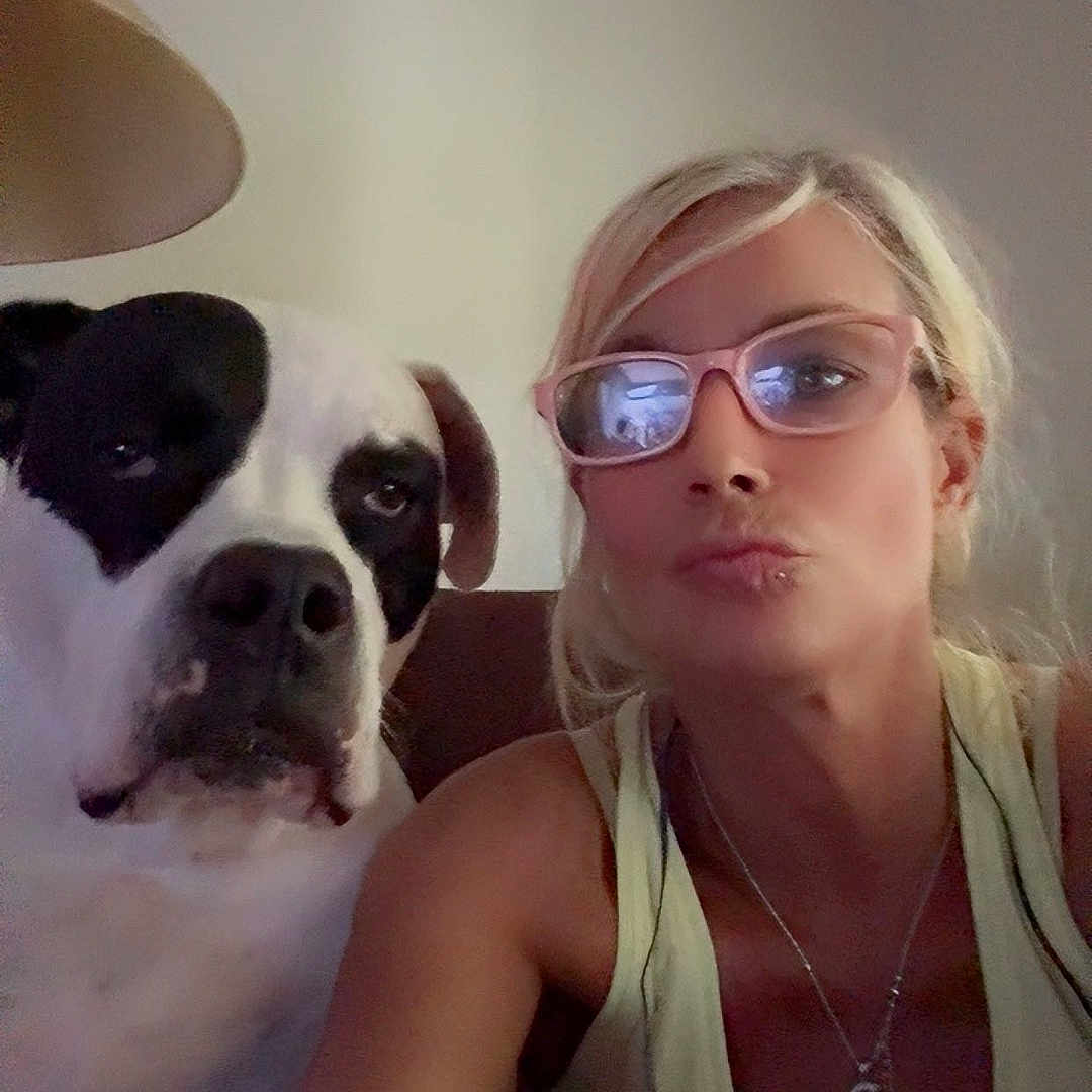 Piggie is registered to the contest to win money with this photo: black_and_white, casual, closeup, companion, dog, framed_picture, furniture, glasses, indoor, lamp, light_skin, living_room, necklace, pet, portrait, reflection, selfie, short_hair, tank_top, woman