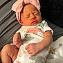 newborn, baby, infant, sleeping, headband, pink, onesie, animal_print, blanket, cozy, cute, small_hands, small_feet, closed_eyes, soft_lighting, indoors, portrait, child, peaceful, resting