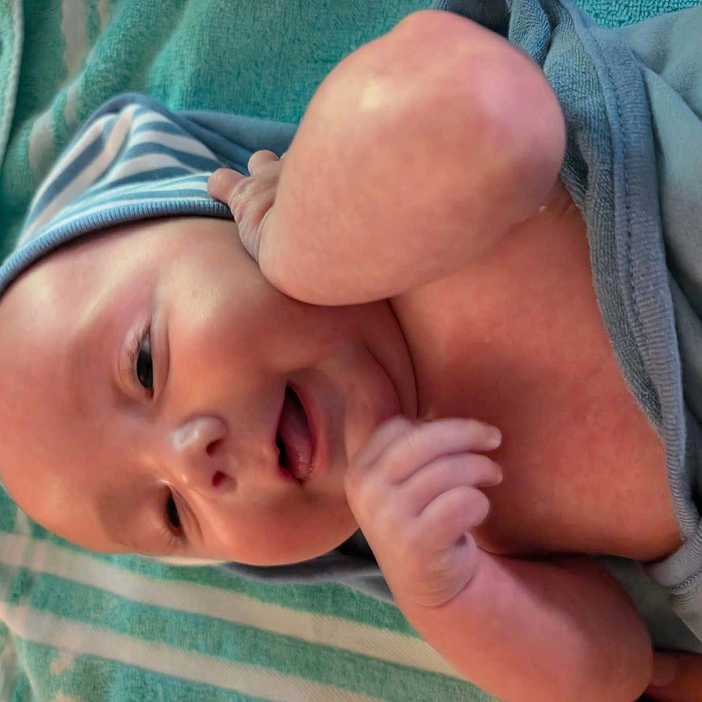 Wylde joined the competition — help win amazing prizes! baby, blanket, child, closeup, comfort, cute, face, hand, happy, indoors, infant, lying_down, newborn, portrait, skin, smiling, soft_texture, striped_hat, towel, warm
