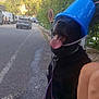 Simba participe au concours pour gagner de l'argent avec cette photo : animal, black_dog, bucket, cars, dog, funny, hat, leash, legs, mountains, nature, outdoor, person, pet, playful, road, roadside, sunlight, tongue_out, trees
