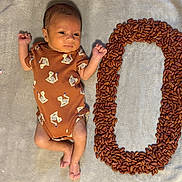 Arita joined the competition — help win amazing prizes! baby, newborn, infant, blanket, onesie, tiger_print, beans, number_zero, colorful, striped, soft_texture, cute, lying_down, small_hands, small_feet, face, expression, patterned_clothing, fabric, indoors