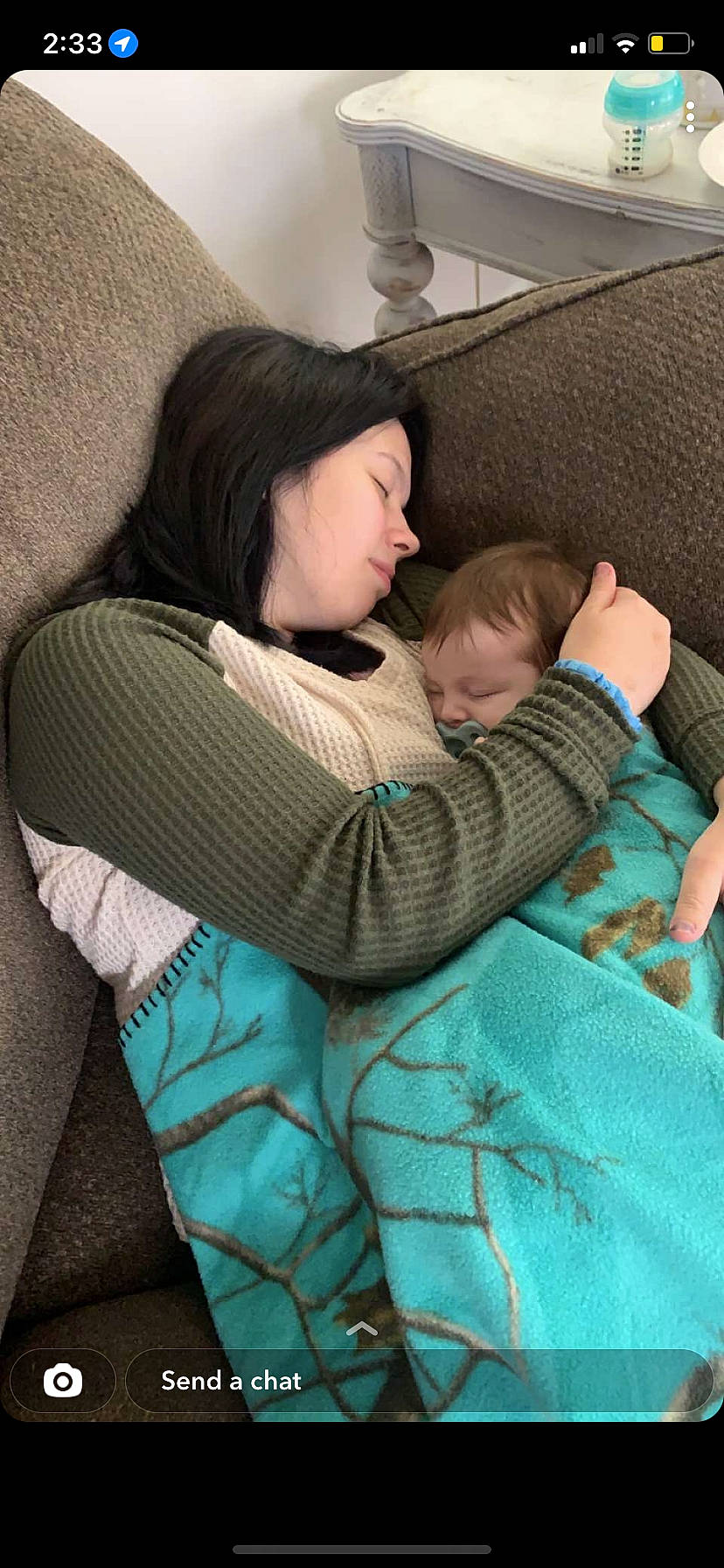 Elayna is registered to the contest to win money with this photo: baby, bag, car_seat, child, comfort, couch, face, gesture, hug, human_leg, lap, leg, linens, mammal, pattern, person, shoulder, sitting, t_shirt, textile