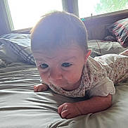 Lila is registered to the contest to win money with this photo: baby, infant, bed, blanket, window, light, indoors, person, clothing, face, skin, hand, pillow, curtains, room, toddler, sleepwear, lying_down, expression, young_child