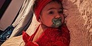 Zénaya participe au concours pour gagner de l'argent avec cette photo : baby, bed, blanket, child, cozy, curious, cute, flower, headband, indoor, infant, lying_down, pacifier, person, portrait, purple_wall, red_clothing, small_feet, soft_texture, window