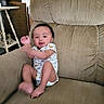 Riley joined the competition — help win amazing prizes! armchair, baby, barefoot, child, clothing, couch, furniture, home, indoors, infant, living_room, onesie, photography, portrait, sitting, smiling, stuffed_animals, warm_lighting, waving, window