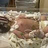 Riley is registered to the contest to win money with this photo: newborn, infant, nicu, incubator, hospital, medical_equipment, monitoring, tubing, medical_tubes, sensors, electrodes, blanket, premature_baby, healthcare, hospital_bed, clinical, pediatric, sleeping, fragile, cartoon_print