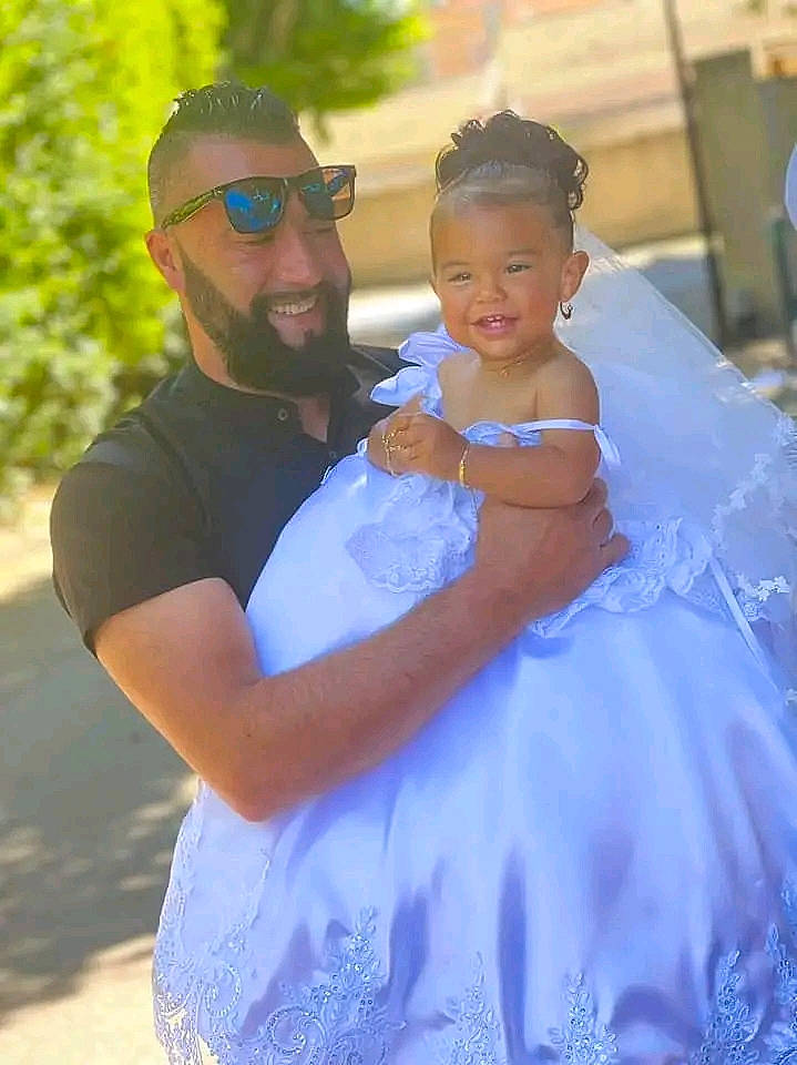 Kenyna a rejoint le concours — aidez-le/la à gagner de superbes lots ! beard, bridal_accessory, bridal_clothing, bridal_party_dress, dress, electric_blue, event, formal_wear, fun, gesture, gown, happy, headpiece, joy, person, shoulder, smile, standing, sunglasses, toddler