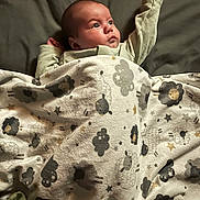 Kyrin is registered to the contest to win money with this photo: baby, infant, blanket, bed, bedding, sleepwear, child, face, portrait, cute, cozy, lying_down, pattern, stars, sheep, soft, warm, expression, resting, indoors