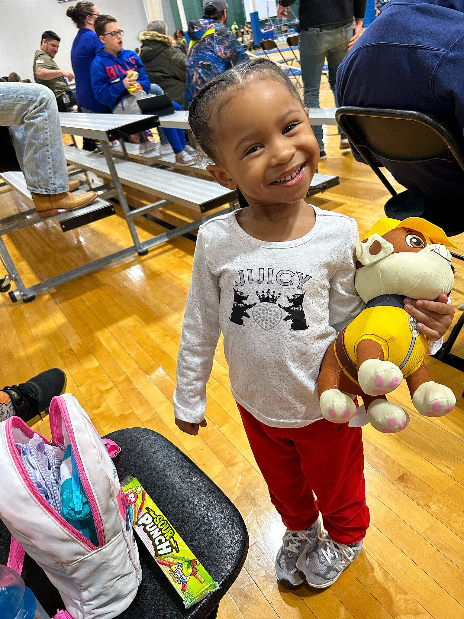 India is registered to the contest to win money with this photo: baby, backpack, bag, chair, child, event, flooring, fun, happy, joy, leisure, luggage_and_bags, person, play, recreation, shoe, smile, sneakers, sportswear, t_shirt