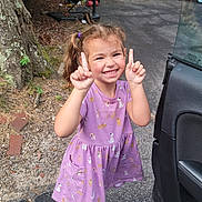 Evangeline joined the competition — help win amazing prizes! child, smiling, girl, purple_dress, pigtails, outdoor, car, open_car_door, driveway, trees, logs, playful, happy, person, footwear, asphalt, nature, daylight, posing, casual_clothing