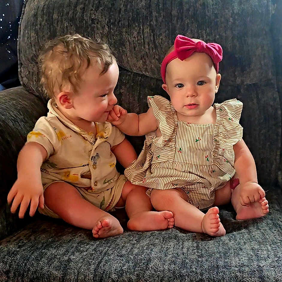 Peyton And Parker is registered to the contest to win money with this photo: baby, babies, child, infant, toddler, cute, clothing, headband, pink_bow, striped_dress, yellow_outfit, sitting, chair, furniture, indoor, hand_touch, barefoot, portrait, face, expression