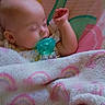 baby, sleeping, pacifier, blanket, rainbow_pattern, infant, child, resting, soft, pastel_colors, cozy, cute, comfort, bedtime, face, head, hand, clothing, seat, nursery