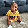 Layla is registered to the contest to win money with this photo: baby, child, smile, sitting, carpet, couch, yellow_clothing, white_socks, bow, braided_hair, indoor, happy, cute, portrait, infant, girl, home, floor, toddler, person