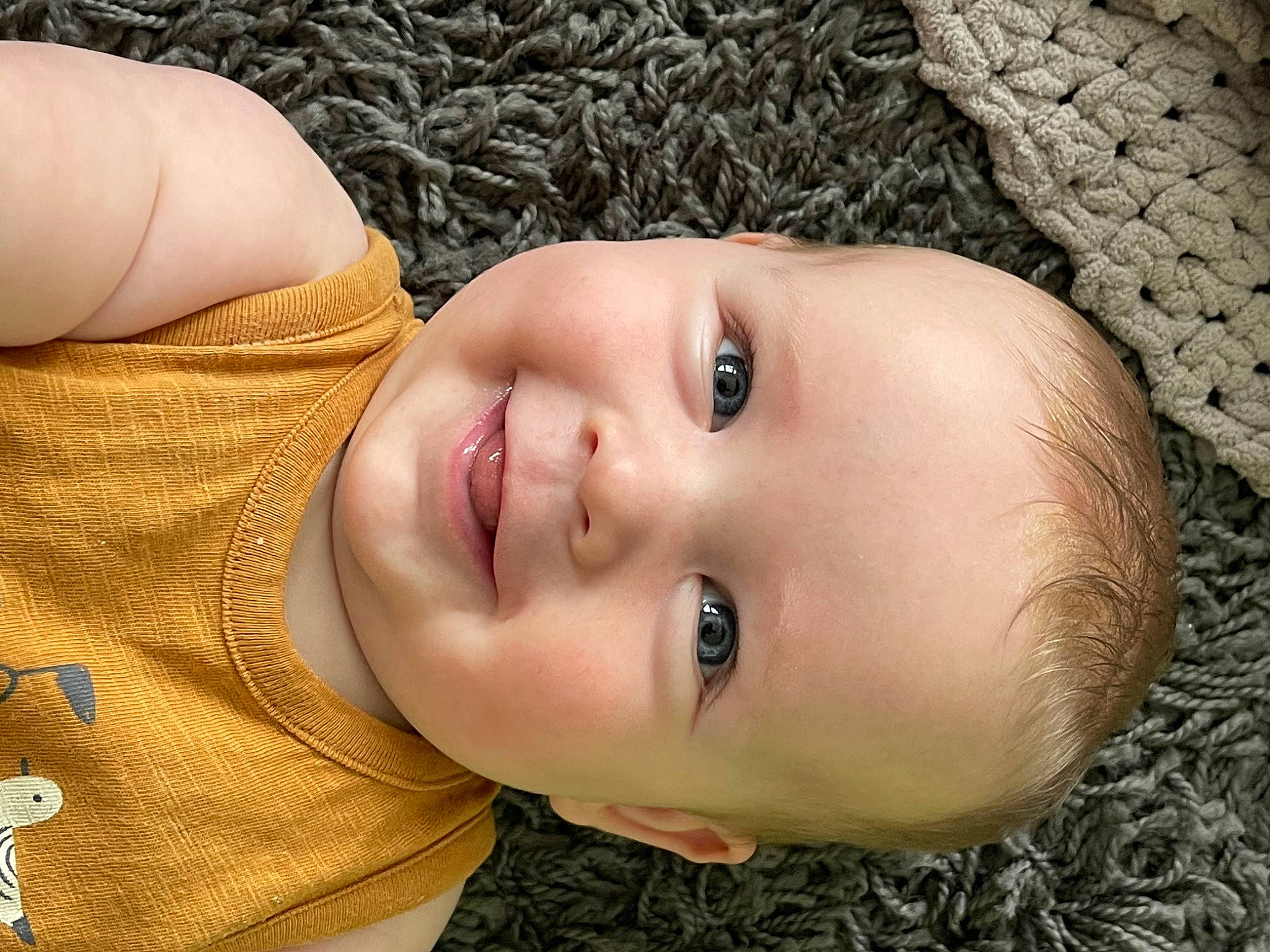 Camden is registered to the contest to win money with this photo: baby, black_hair, cheek, eye, eyebrow, eyelash, flash_photography, grass, hair, happy, iris, joy, lip, nose, people_in_nature, person, plant, skin, smile, toddler