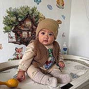 Aiden is registered to the contest to win money with this photo: baby, butterfly, changing_pad, child, clothing, cute, fox, indoor, infant, knit_hat, nursery, person, playful, smile, socks, sun, toy, treehouse, vest, wall_mural