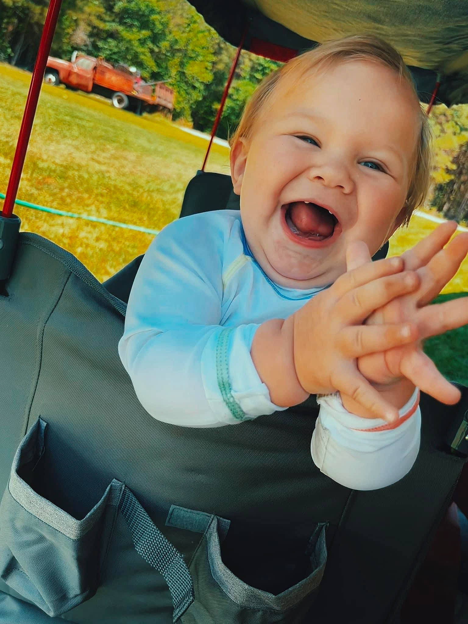 Trace is registered to the contest to win money with this photo: automotive_tire, baby_laughing, baby_toddler_clothing, finger, fun, gesture, grass, hand, happy, leisure, person, plant, recreation, smile, swing, thumb, tire, toddler, tree, wheel