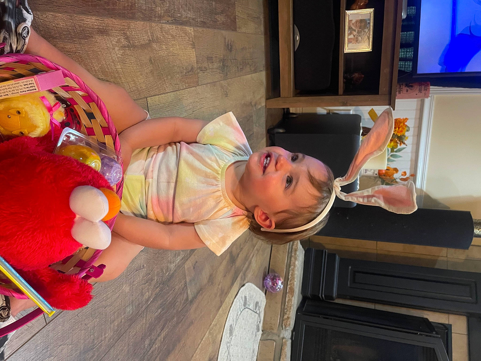 Reagan is registered to the contest to win money with this photo: abdomen, baby, child, display_device, flesh, flooring, fun, happy, hat, human_leg, joy, kitchen, person, picture_frame, play, room, sandal, t_shirt, television, thigh