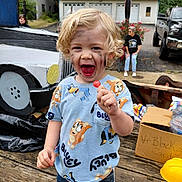 Aiden joined the competition — help win amazing prizes! child, blond_hair, lollipop, face_paint, blue_tshirt, cartoon_print, cardboard_car, wooden_deck, box, toy_car, people, outdoor, smiling, happy, curly_hair, casual_clothing, daylight, garage, vehicle, playful
