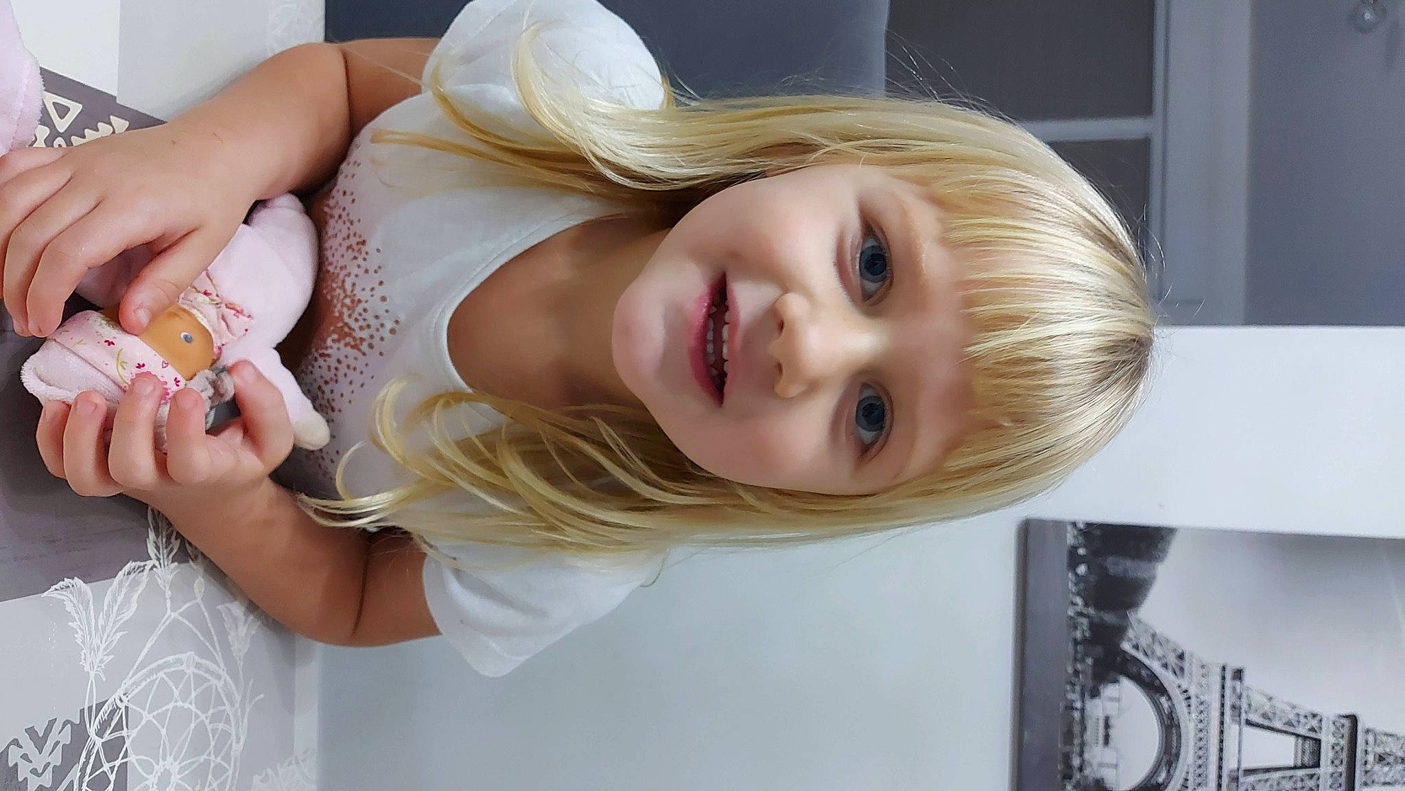Lola participe au concours pour gagner de l'argent avec cette photo : blond, brown_hair, child, dress, eye, eyelash, fun, gesture, hairstyle, happy, iris, jewellery, joy, layered_hair, lip, person, portrait_photography, room, skin, smile