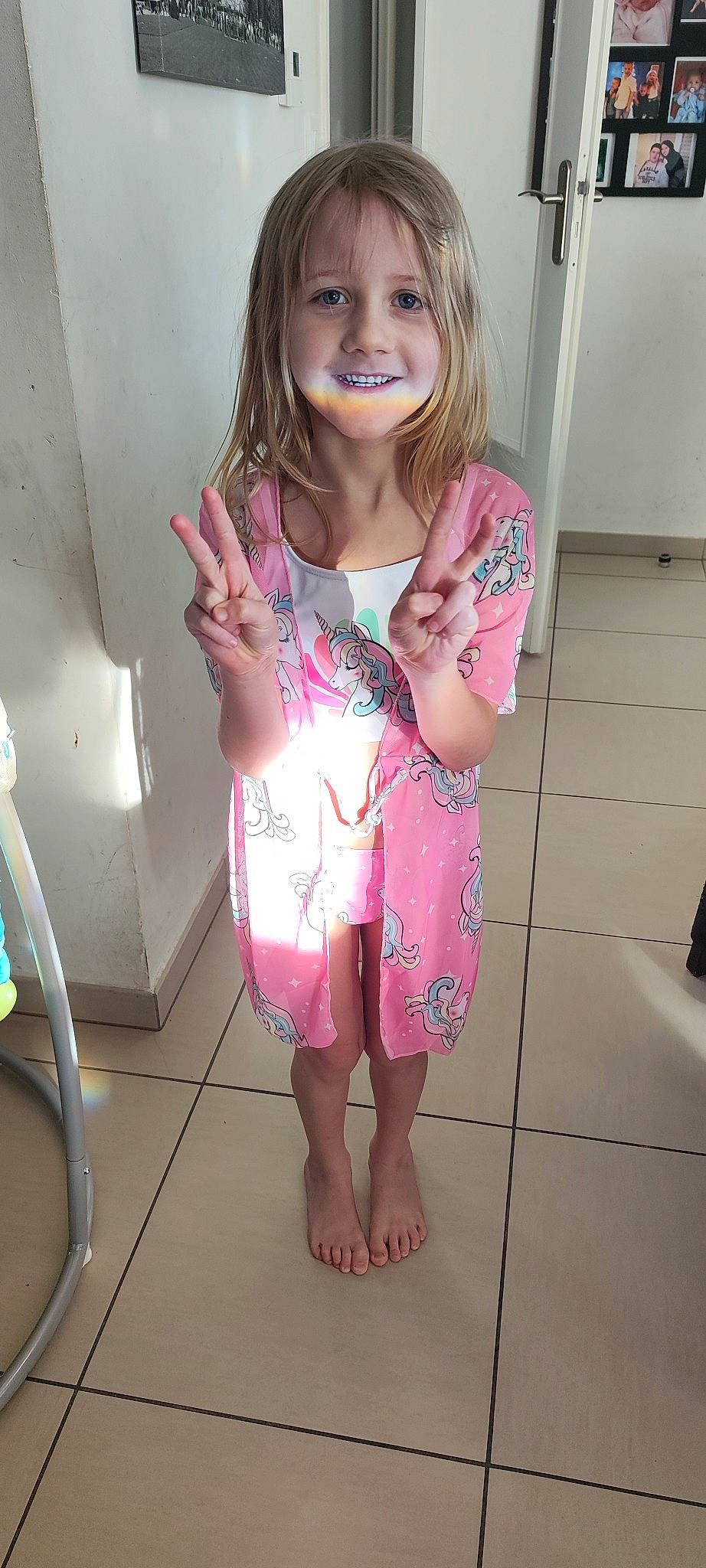 Lola a rejoint le concours — aidez-le/la à gagner de superbes lots ! baby_toddler_clothing, dress, fawn, finger, flooring, gesture, hair, hand, happy, head, human_body, joy, leg, person, pink, skin, sleeve, smile, standing, thumb