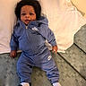 baby, child, infant, nike, tracksuit, blue_clothing, socks, couch, pillow, indoor, person, face, smile, relaxing, young_child, curious, seated, furniture, home, casual