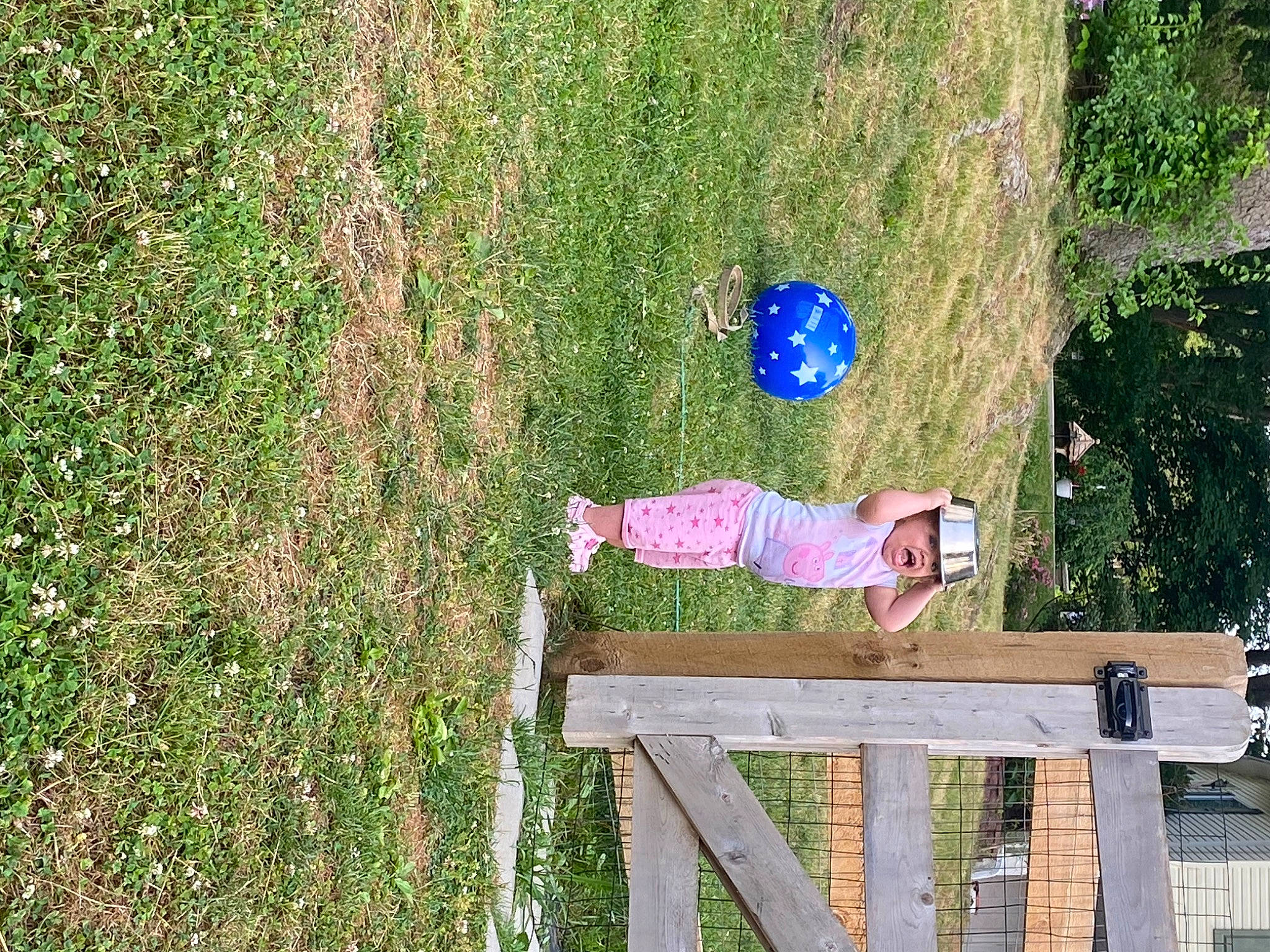 Sophia is registered to the contest to win money with this photo: baby, fun, garden, grass, grass_family, grassland, headwear, landscape, lawn, leisure, outdoor_furniture, pasture, people_in_nature, person, plant, recreation, shadow, shrub, toddler, tree