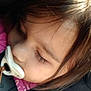 child, toddler, sleeping, pacifier, blanket, car_seat, face, hair, closeup, peaceful, resting, indoors, young_child, infant, seatbelt, cozy, soft_light, portrait, baby, nap