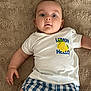 baby, infant, child, tshirt, lemon, blue_shorts, checkered, carpet, floor, lying_down, eyes_open, cute, casual_clothing, indoor, skin, hand, portrait, expression, young, person