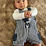 baby, bear_design, blanket, blue_eyes, casual, child, clothing, comfortable, cute, hands, indoor, infant, lying_down, person, portrait, skin, smiling, soft_texture, striped_overall, young