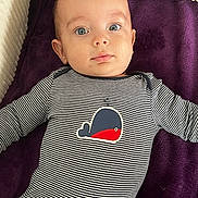 élio a rejoint le concours — aidez-le/la à gagner de superbes lots ! baby, infant, child, onesie, striped_clothing, whale_graphic, blanket, purple_blanket, lying_down, blue_eyes, face, head, cute, portrait, indoors, soft_lighting, young_child, clothing, person, baby_girl_or_boy