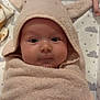 baby, infant, towel, hooded_towel, wrapped, cute, face, eyes, blanket, cloud_pattern, star_pattern, soft_texture, child, indoors, lying_down, plush, newborn, skin, expression, cozy