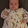 Poppy joined the competition — help win amazing prizes! baby, infant, face, child, dress, patterned_clothing, cartoon, deer, floral, cute, lying_down, hands, fingers, skin, person, portrait, young, closeup, indoor, soft_lighting