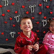 Oliver participe au concours pour gagner de l'argent avec cette photo : backdrop, boy, child, decoration, fabric, festive, girl, happy, hearts, indoor, pajamas, pearl_bows, portrait, red_pajamas, siblings, sitting, smile, smiling, watermark, young_child