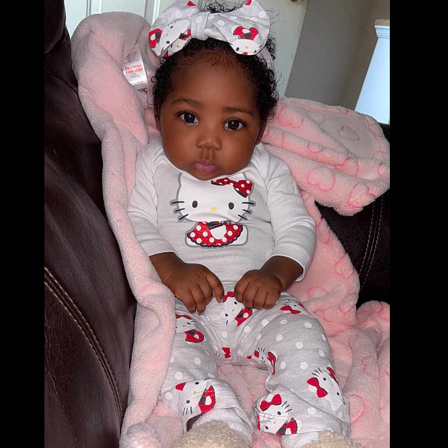 Kaimee is registered to the contest to win money with this photo: baby, bodypart, bonnet, clothing, couch, crib, cushion, face, finger, footwear, furniture, hand, hat, head, homedecor, infantbed, person, photography, portrait, shoe