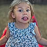 Astrid is registered to the contest to win money with this photo: child, toddler, girl, face, tongue_out, blue_dress, floral_pattern, outdoor, playground, slide, blurry_background, casual_clothing, cute, smiling, funny_face, young_child, summer, daylight, person, portrait