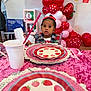 toddler, child, party, birthday, balloons, strawberry, table, plates, pink, red, headband, cutlery, cup, person, indoor, celebration, decorations, curious, festive, adult