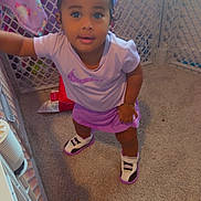 Heaven joined the competition — help win amazing prizes! toddler, child, playpen, bow, purple_outfit, sneakers, carpet, toy, blanket, indoor, curious, smiling, person, footwear, candid, baby, bracelet, headwear, floor, home