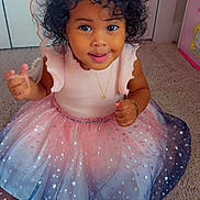 Heaven joined the competition — help win amazing prizes! toddler, child, smiling, curly_hair, dress, star_pattern, sandals, carpet, indoor, jewelry, necklace, bracelet, happy, cute, person, baby, fashion, playful, sitting, portrait