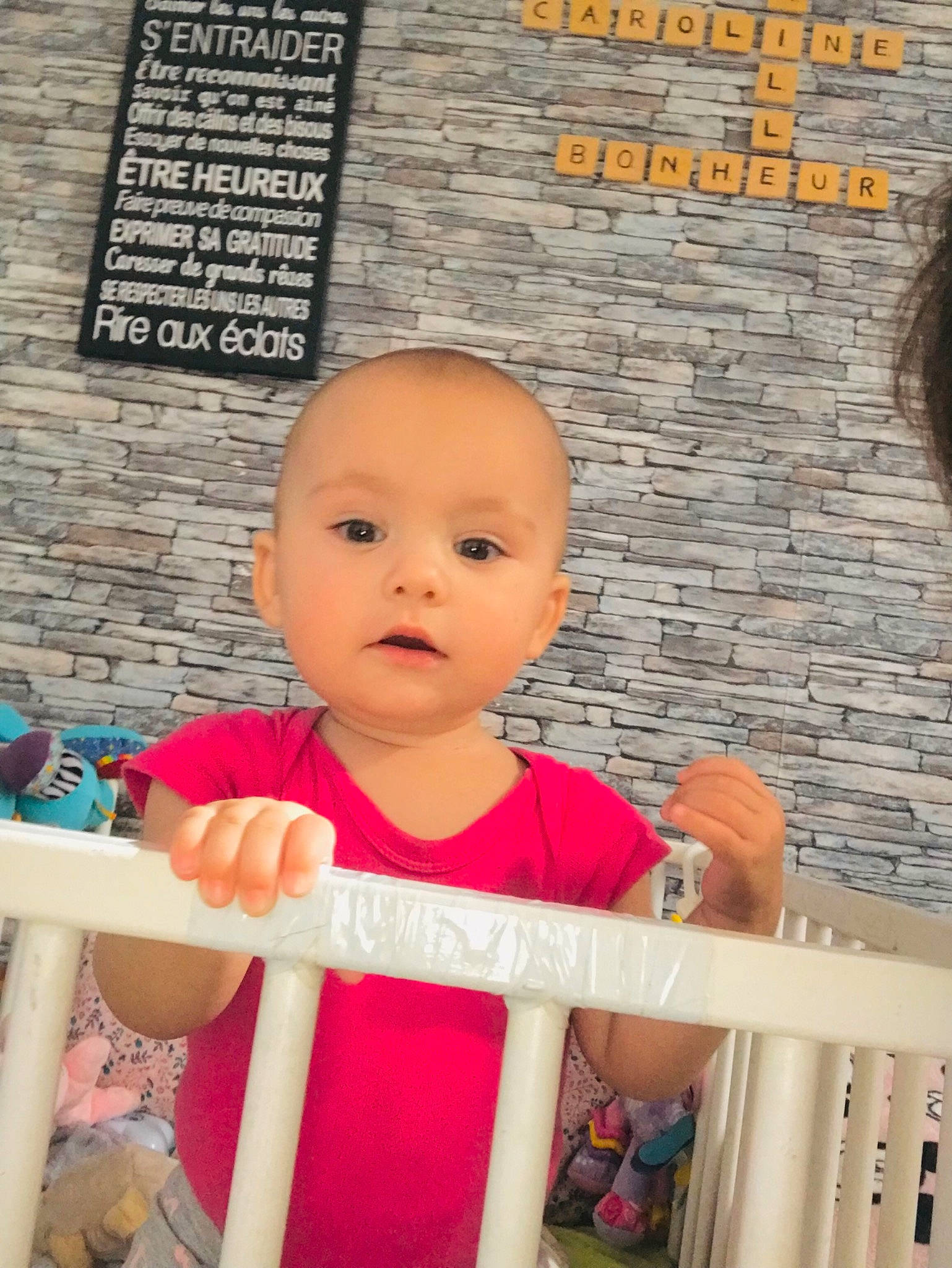 Louisa participe au concours pour gagner de l'argent avec cette photo : baby, baby_products, baby_toddler_clothing, brick, brickwork, cheek, child, font, fun, happy, leisure, magenta, person, pink, room, sitting, sleeve, t_shirt, toddler, travel