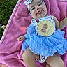 Aria joined the competition — help win amazing prizes! baby, infant, child, pink_blanket, blue_tutu, headband, milestone_plaque, grass, outdoor, tongue_out, cute, playful, smiling, person, clothing, legs, arms, face, sitting, blanket