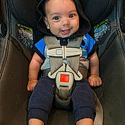 Malakai is registered to the contest to win money with this photo: baby, infant, car_seat, child, smile, hoodie, seatbelt, safety, cute, blue_clothing, happy, person, foot, hand, straps, seat, indoors, portrait, young_child, looking_at_camera