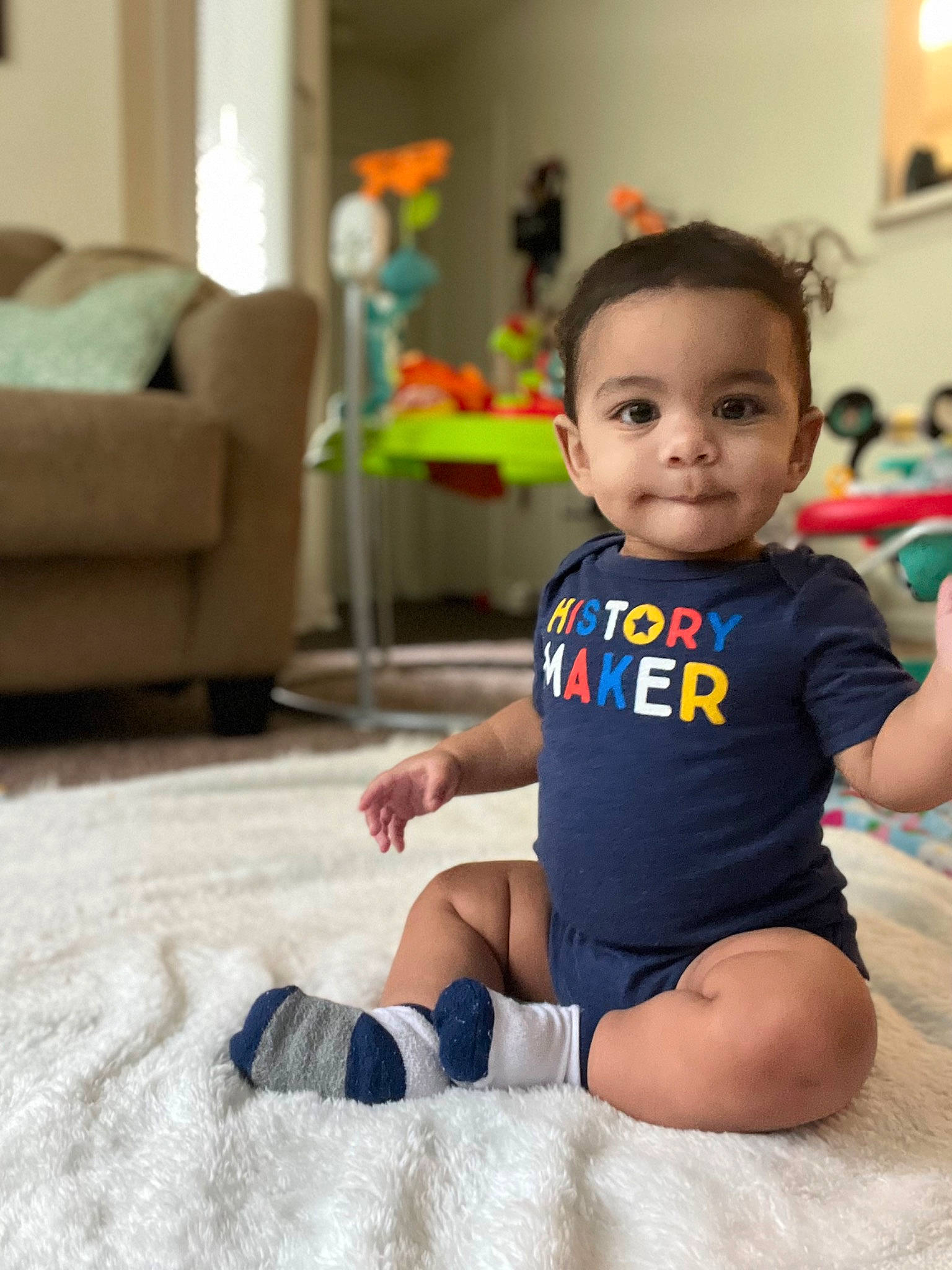 Kamdyn is registered to the contest to win money with this photo: baby, baby_toddler_clothing, child, comfort, couch, floor, flooring, fun, happy, human_leg, joy, knee, leg, leisure, person, sitting, skin, sleeve, smile, t_shirt
