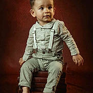 Mélyo a rejoint le concours — aidez-le/la à gagner de superbes lots ! toddler, child, boy, suspenders, barefoot, books, stack, portrait, studio, brown_background, curious, clothing, sitting, indoors, young_child, cute, fashion, expression, person, photography