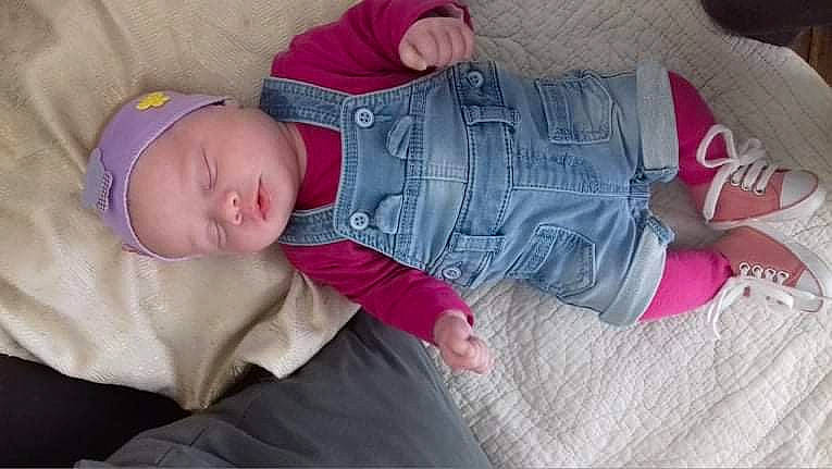 Chelsea participe au concours pour gagner de l'argent avec cette photo : baby, baby_sleeping, baby_toddler_clothing, cheek, clothing, comfort, eye, glasses, hand, headgear, headwear, human_body, lap, leg, mouth, person, pink, purple, skin, sleeve
