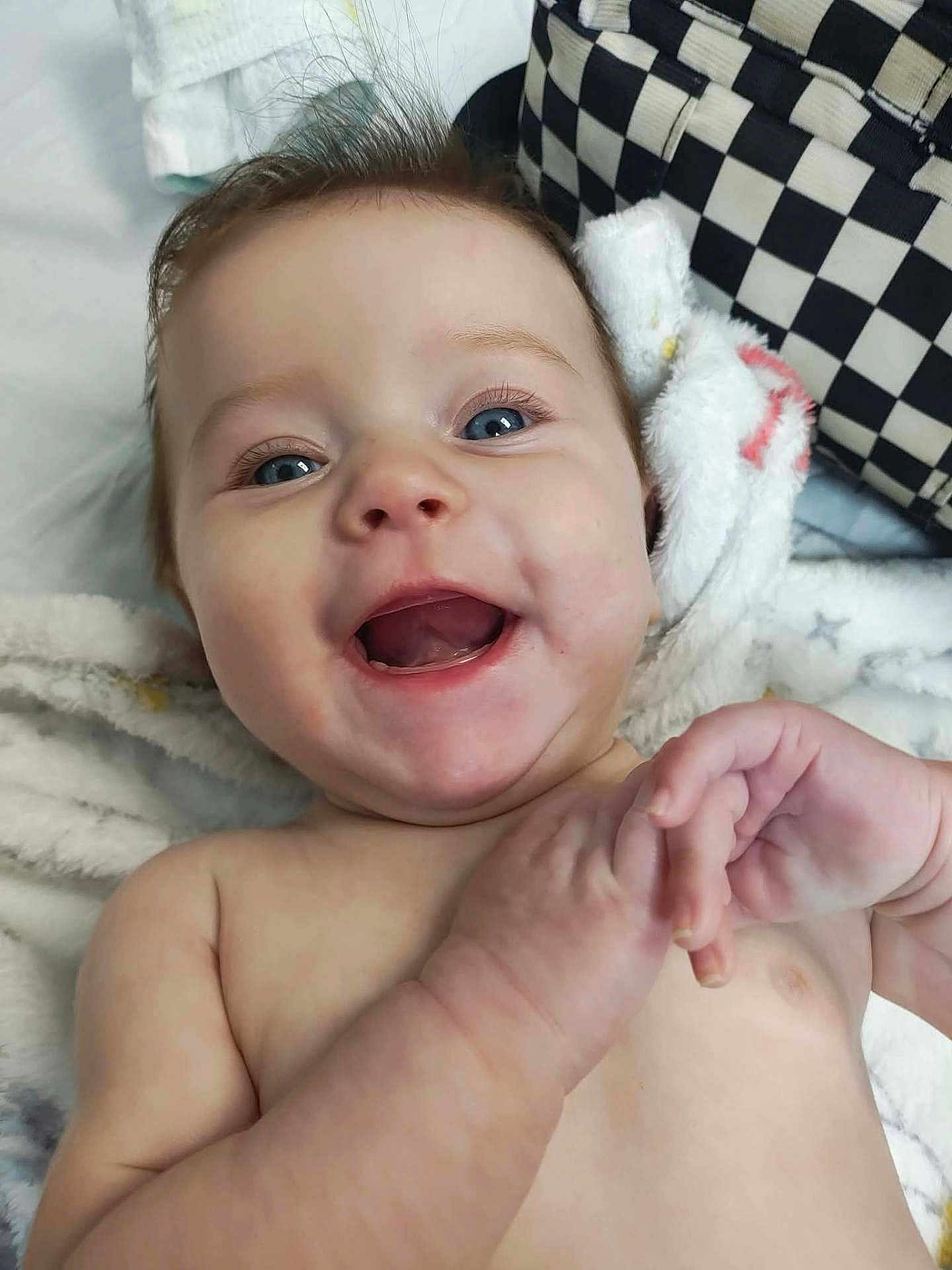 Arabella joined the competition — help win amazing prizes! baby, infant, smiling, happy, face, blue_eyes, hands, blanket, skin, hair, cheeks, mouth, teeth, closeup, person, toddler, indoor, candid, expression, joyful