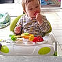Cassidy participe au concours pour gagner de l'argent avec cette photo : baby, child, clothing, cute, expression, floor, food, furniture, hand, head, home, indoor, munching, person, playroom, seat, snack, table, toy, walker