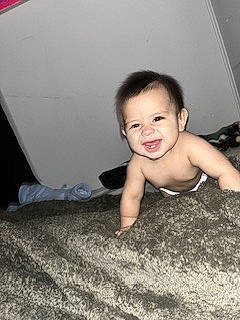 Jorge is registered to the contest to win money with this photo: baby, chest, comfort, crawling, elbow, eyebrow, flash_photography, floor, flooring, fun, happy, hardwood, human_leg, joy, nose, person, room, sitting, skin, smile