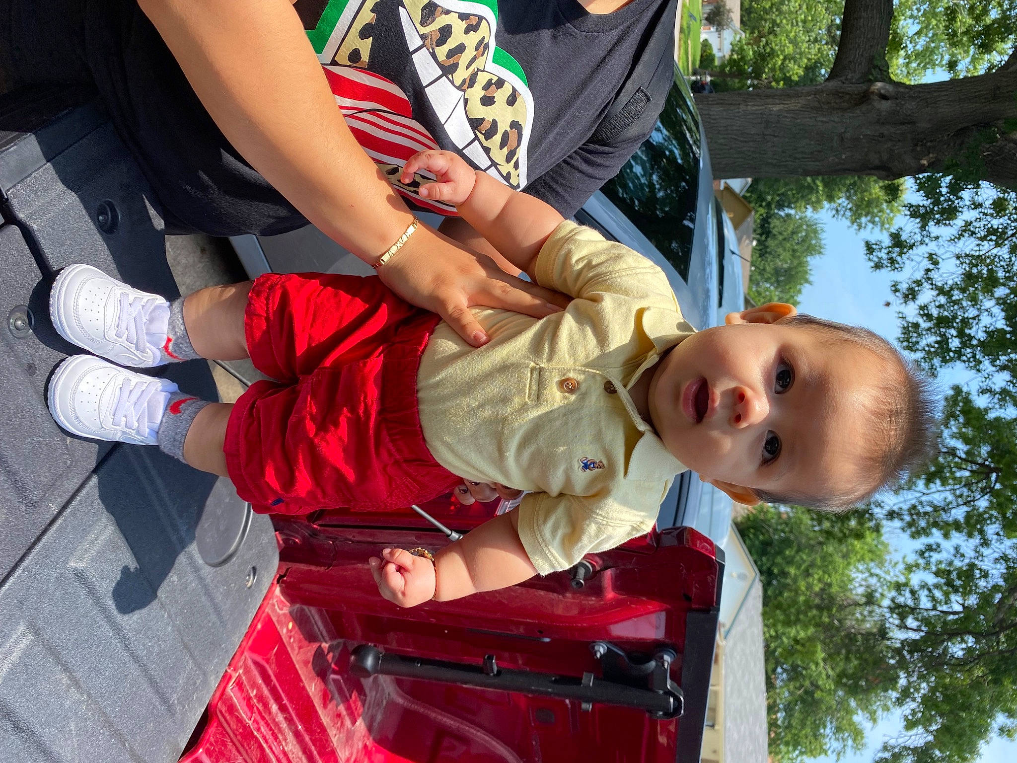 Jorge is registered to the contest to win money with this photo: baby, child, event, fun, gesture, grass, happy, human_leg, lap, leisure, person, plant, recreation, sitting, sky, smile, surprise, thigh, toddler, tree