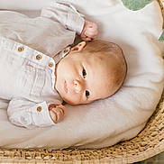 Léandre a rejoint le concours — aidez-le/la à gagner de superbes lots ! baby, infant, basket, blanket, greenery, leaves, soft, cute, newborn, face, portrait, cozy, white_clothing, wooden_texture, natural_light, peaceful, resting, small_hands, lying_down, closeup