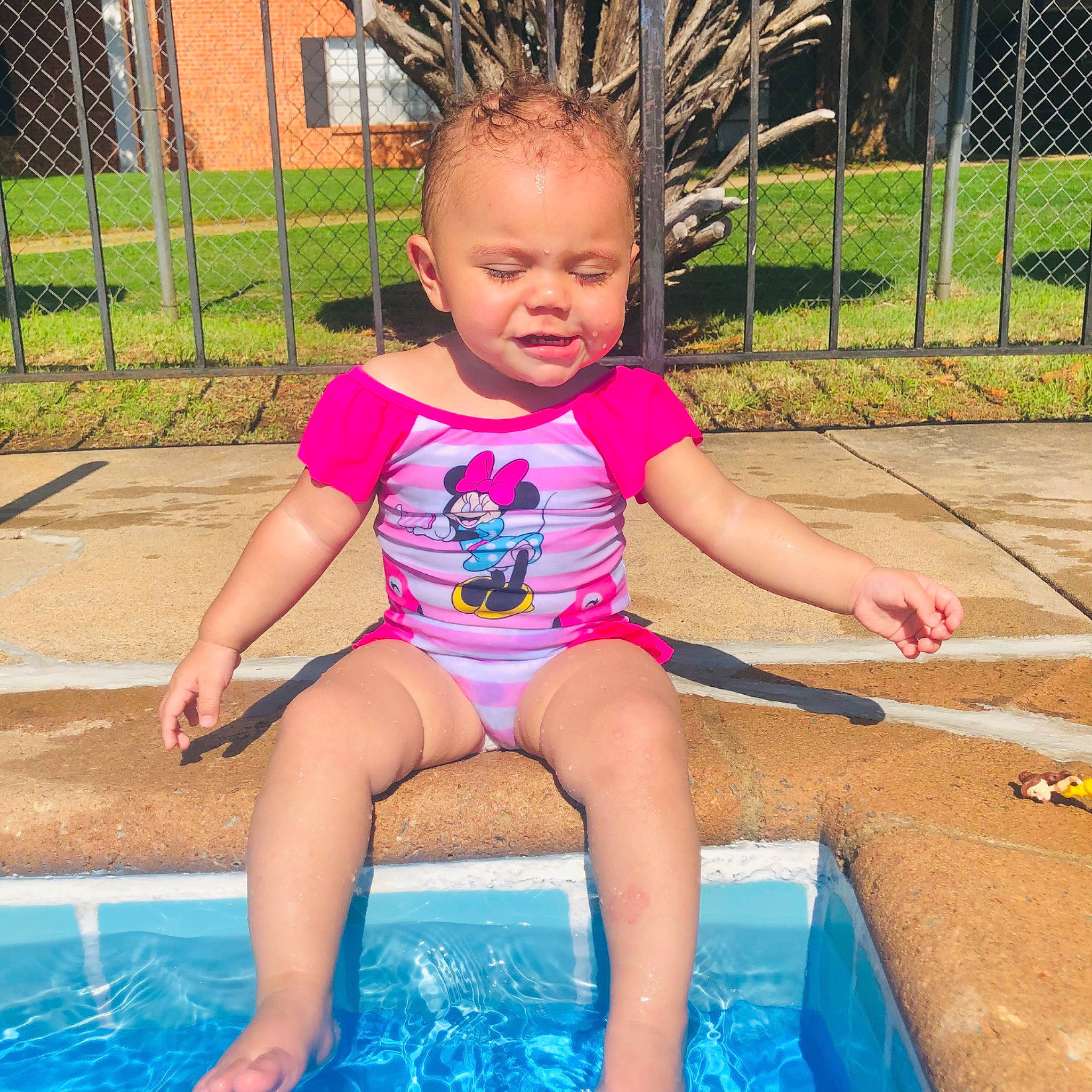 Zaryah is registered to the contest to win money with this photo: baby_toddler_clothing, barefoot, bathing, beauty, child, facial_expression, fence, fun, grass, happy, leisure, outdoor_play_equipment, person, pink, public_space, recreation, summer, swimming_pool, thigh, toddler